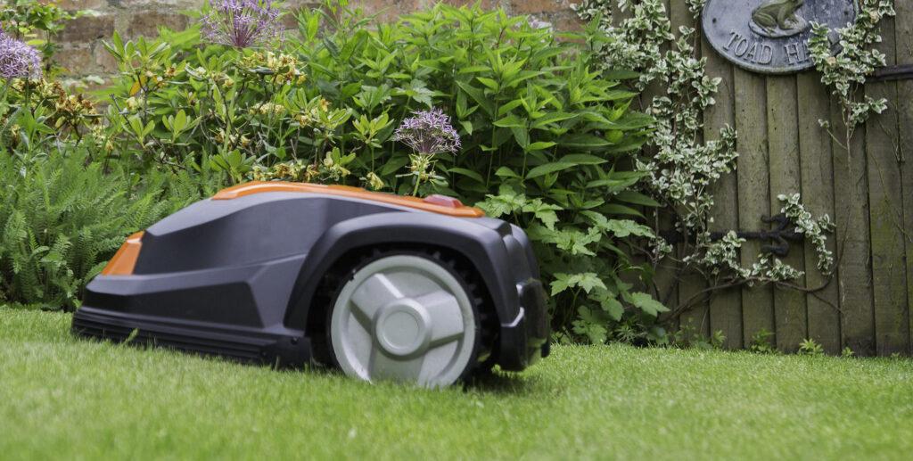 Robotgräsklippare av modell YardForce som klipper gräset i trädgård